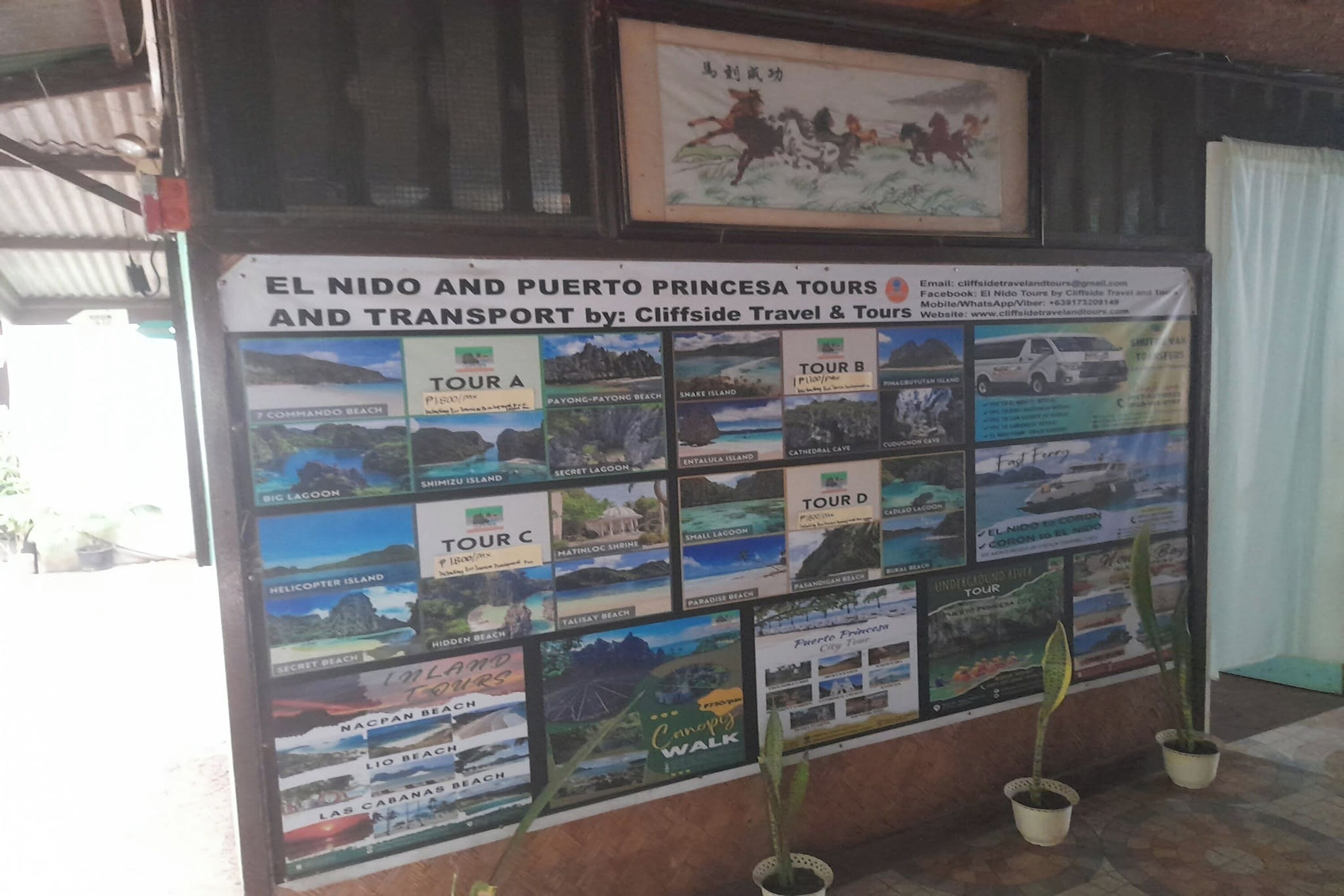 A travel information board with various tour options and a sign for El Nido and Puerto Princesa tours.