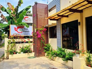A building with a sign for 'Casa Teefista' and a wooden structure with climbing plants. - Hotel Casa Teofista (Panglao)
