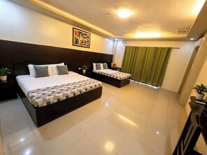 A hotel room with two beds, a large painting on the wall, a green curtain, and a potted plant. - Hotel Casa Teofista (Panglao)