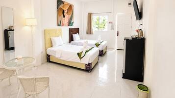 A hotel room with a bed, a desk, a chair, a TV, and a window.
