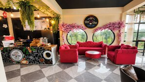 Een café interieur met een koffieapparaat, zithoek en decoratieve planten.