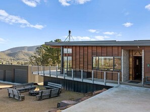 A modern building with a fire pit and outdoor seating area. - Ridge Way Views - Breathtaking Lake Eildon Views (Mountain Bay)