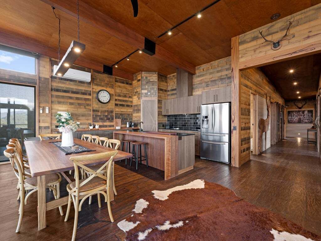 A spacious kitchen with wooden cabinetry, a central island, and a large refrigerator.