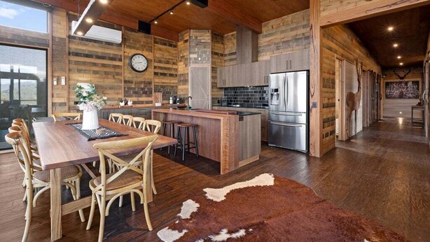 A spacious kitchen with wooden cabinetry, a central island, and a large refrigerator. - Ridge Way Views - Breathtaking Lake Eildon Views (Mountain Bay)