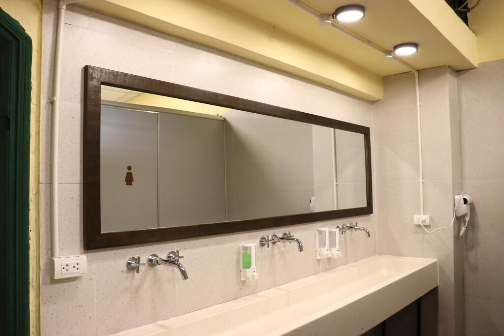 Un bagno con uno specchio grande, due lavabi e un dispenser per asciugamani.