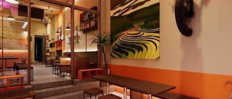 A modern interior with a long wooden table and benches, a large wall painting, and a unique tire mounted on the wall.