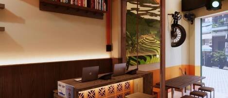 A reception area with a wooden desk, a laptop, and a bookshelf.