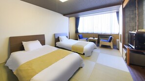 A hotel room with two beds, a small table, a chair, a TV, and a window with curtains. - OSHUKUONSEN YUTORELOSHIZUKUISHI (Shizukuishi)