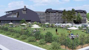 Un patio con mobiliario exterior, una zona vallada para perros y un edificio con varias ventanas y balcones.
