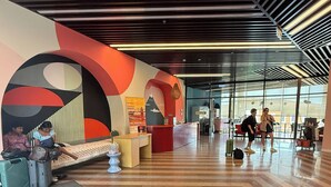 Un lobby espacioso con un diseño moderno, que incluye una recepción, zona de estar y espacio para equipaje.