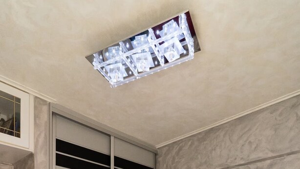 A bedroom with a bed, a nightstand, a wall-mounted shelf, a painting, and a ceiling light fixture. - Coastal Haven οf Piraeus - by ΜΡS (Pireas)