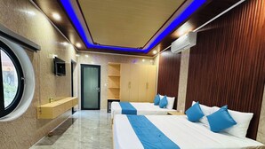 A modern hotel room with two beds, a built-in wardrobe, a small desk, and a window. - Hoi An Ocean Waves Homestay (Da Nang)