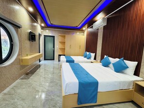 Una moderna camera d'albergo con due letti, un armadio a muro, una piccola scrivania e una finestra.