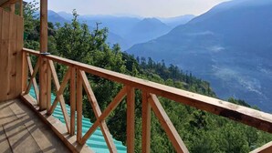 Un balcón de madera con vista a un paisaje montañoso.