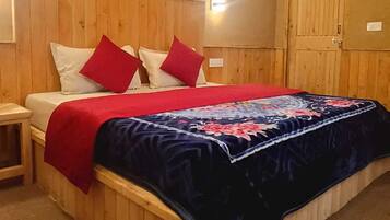 Habitación con paneles de madera, una cama, una mesita de noche y un aplique de pared.