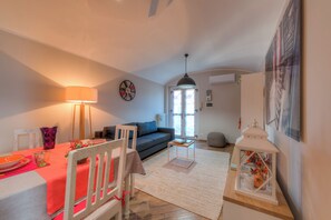 A cozy living room with a dining area, a sofa, a lamp, and a decorative lantern. - Bon Bon - Charm in the City Center (Torino)