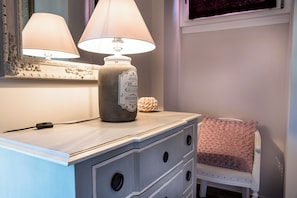 A bedside table with a lamp, a decorative vase, and a small chair with a blanket. - Bon Bon - Charm in the City Center (Torino)