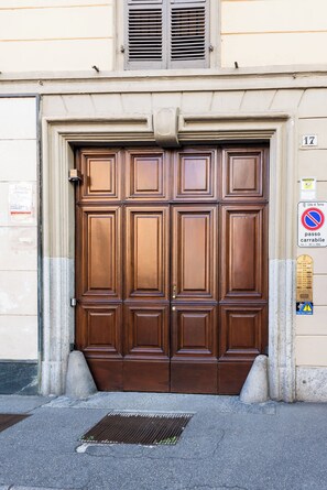 A large, ornate wooden double door with a number '17' above it, set in a beige building facade. - Bon Bon - Charm in the City Center (Torino)
