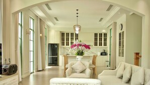 A spacious living area with a sofa, ottoman, and a dining table with chairs. - Ngoc Khanh Villas Bai Khem Phu Quoc (Phu Quoc)