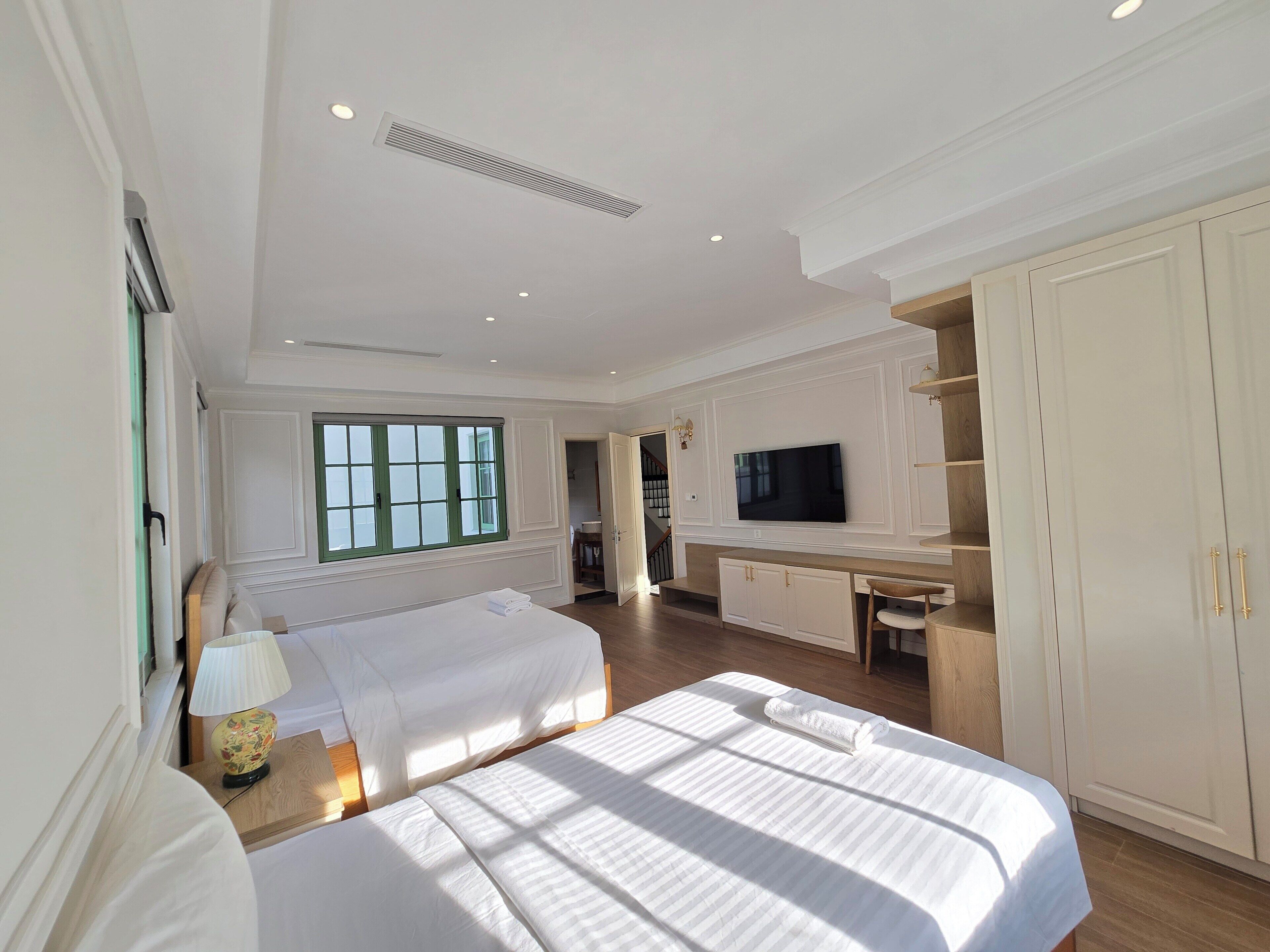Una camera d'albergo con un letto, una scrivania con televisore e un armadio.