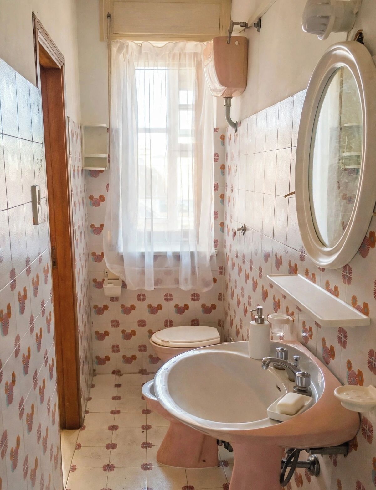 Un bagno con lavandino, WC e specchio.