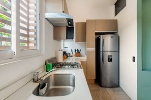 A modern kitchen with a stainless steel refrigerator, a gas stove, and a sink. - Coral 55 · 3 blocks from Marina l La Cruz · Bathtub and pool (Cruz de Huanacaxtle)