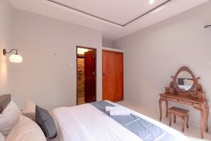 Une chambre à coucher comprenant un lit, une table de chevet, un miroir et une armoire.