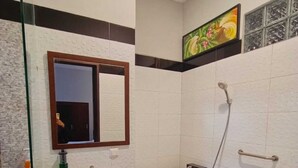 Un baño con lavabo blanco, espejo, bañera y ducha.