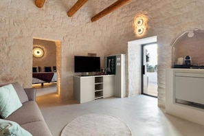 Suite júnior, 1 llit de matrimoni gran i sofà llit, zona enjardinada | Sala d'estar | Televisor intel·ligent de 40 polzades amb canals digitals 