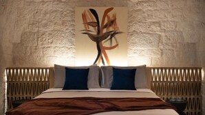 Una cama con cabecera, dos almohadas y una manta.
