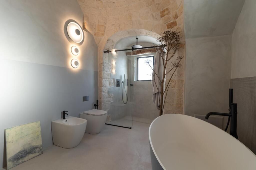 Un baño moderno con una bañera independiente, un lavamanos pedestal y un box de ducha.