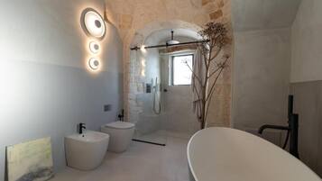Un baño moderno con una bañera independiente, un lavamanos pedestal y un box de ducha.