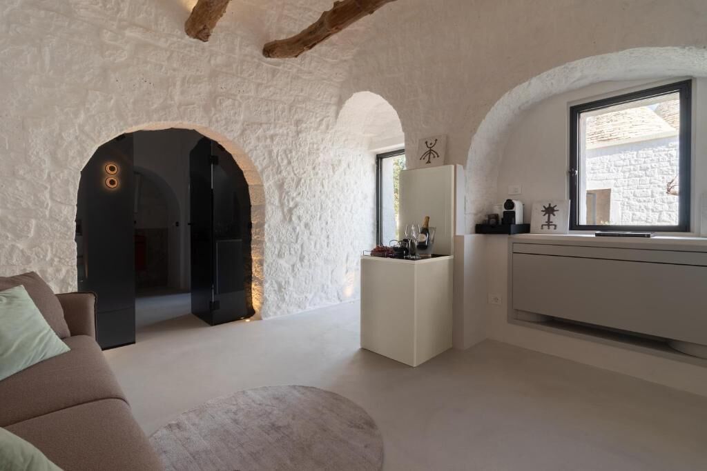 Een modern interieur met een stenen muur, een bank, een ronde tafel en een raam met uitzicht.