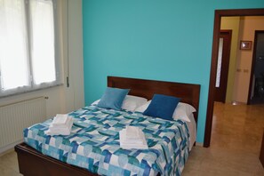 A bed with a checkered bedspread, two pillows, and folded towels. - Apartment in a Villa with a Spa (mezzanego)