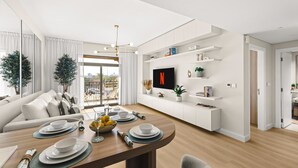 A modern living room with a dining area, a flat-screen TV mounted on the wall, and a balcony with a view. - StayShort | Stylish 1BR Apartment | Near Burj Al Arab | Family-Friendly | Sleeps 4 (Dubai)