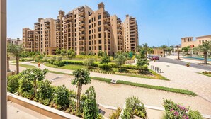 A high-rise residential building with multiple balconies, surrounded by landscaped gardens and a clear sky. - StayShort | Stylish 1BR Apartment | Near Burj Al Arab | Family-Friendly | Sleeps 4 (Dubai)
