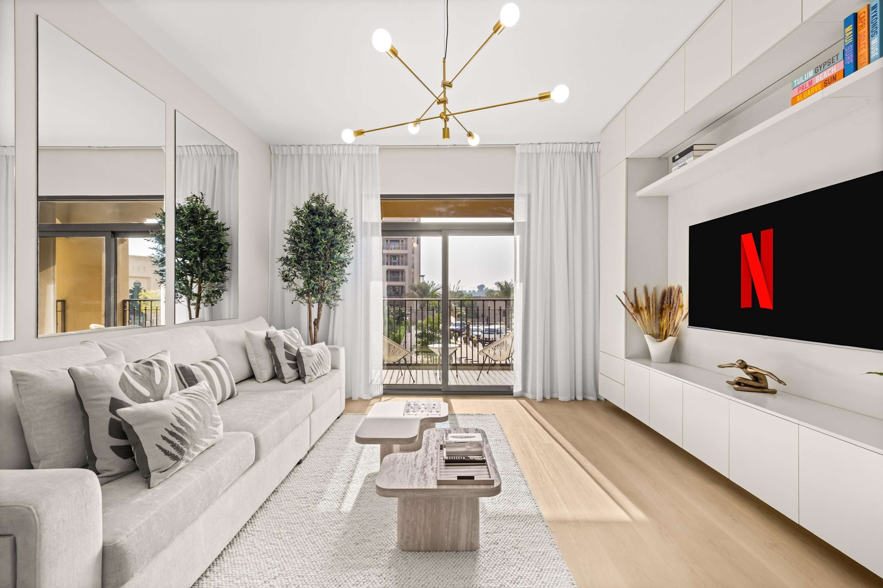 A modern living room with a sofa, coffee table, and a TV mounted on the wall.