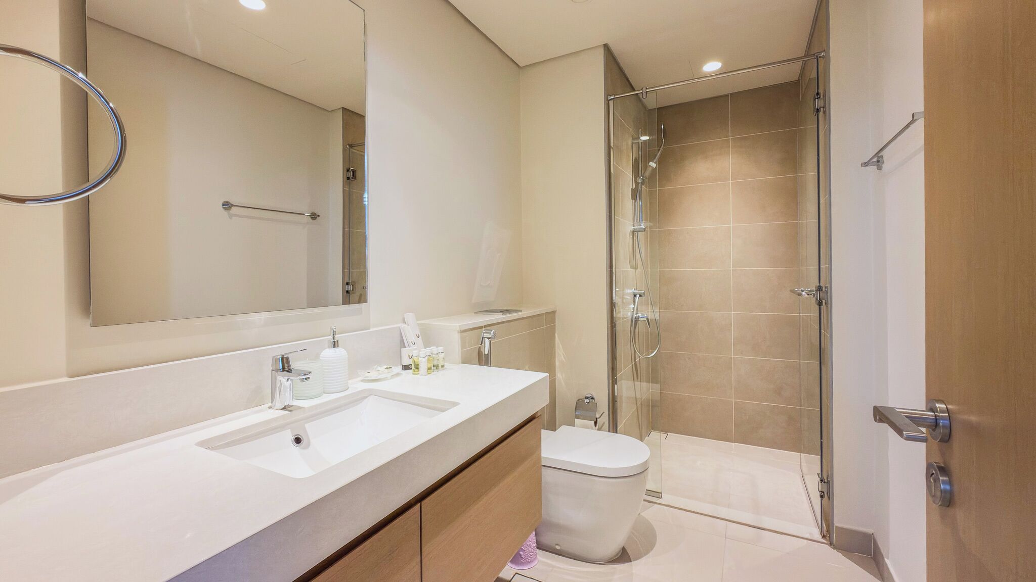A modern bathroom with a shower, a toilet, and a sink.