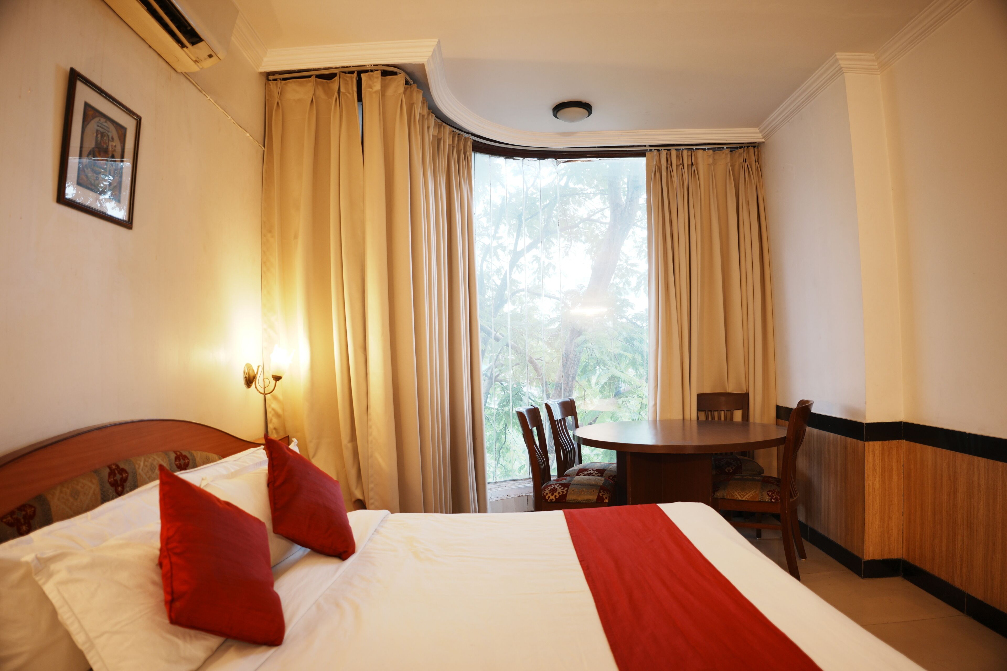 Ein Hotelzimmer mit einem Bett, einem Tisch und Stühlen.