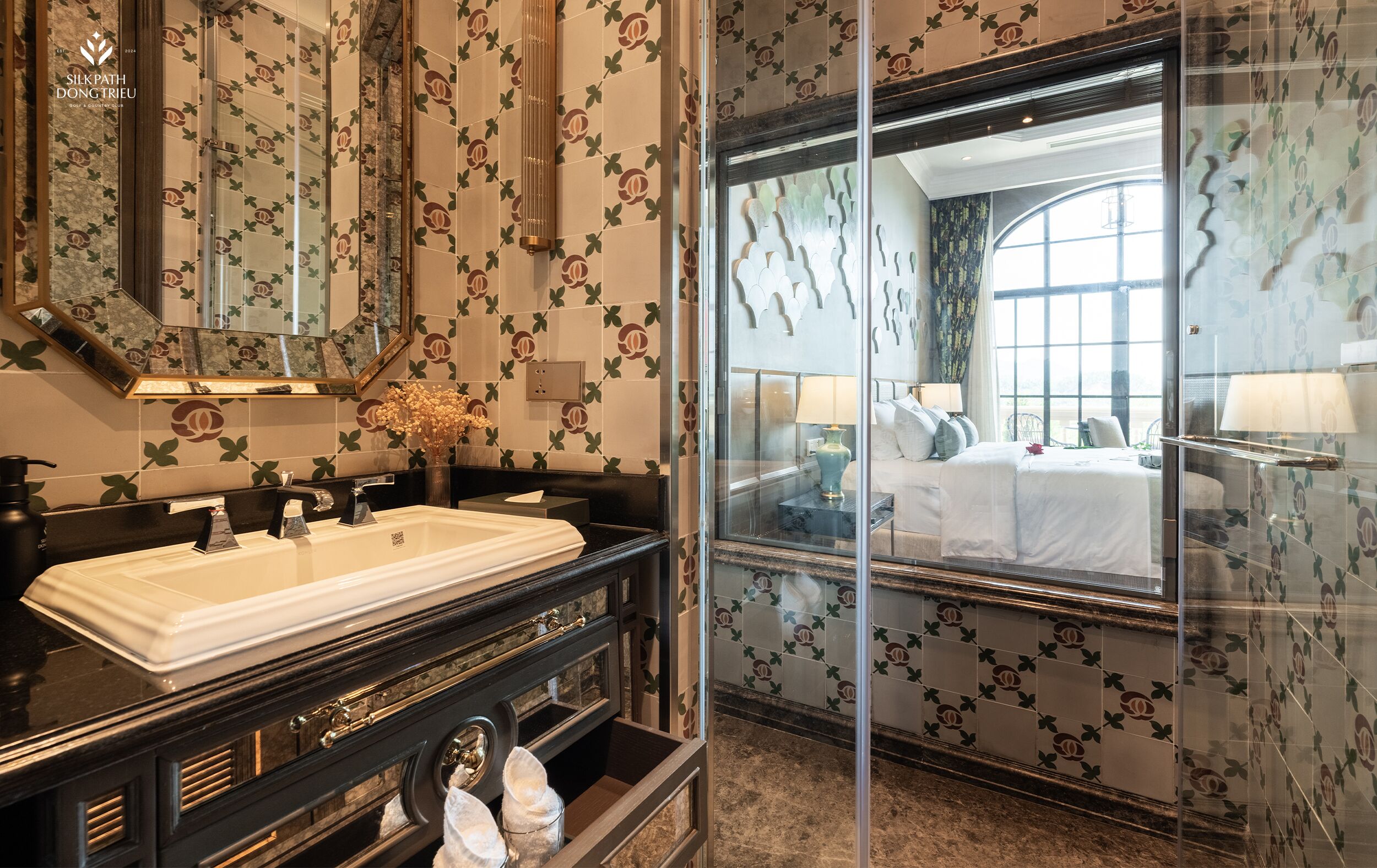 A hotel bathroom with a large mirror, a sink, and a vanity.