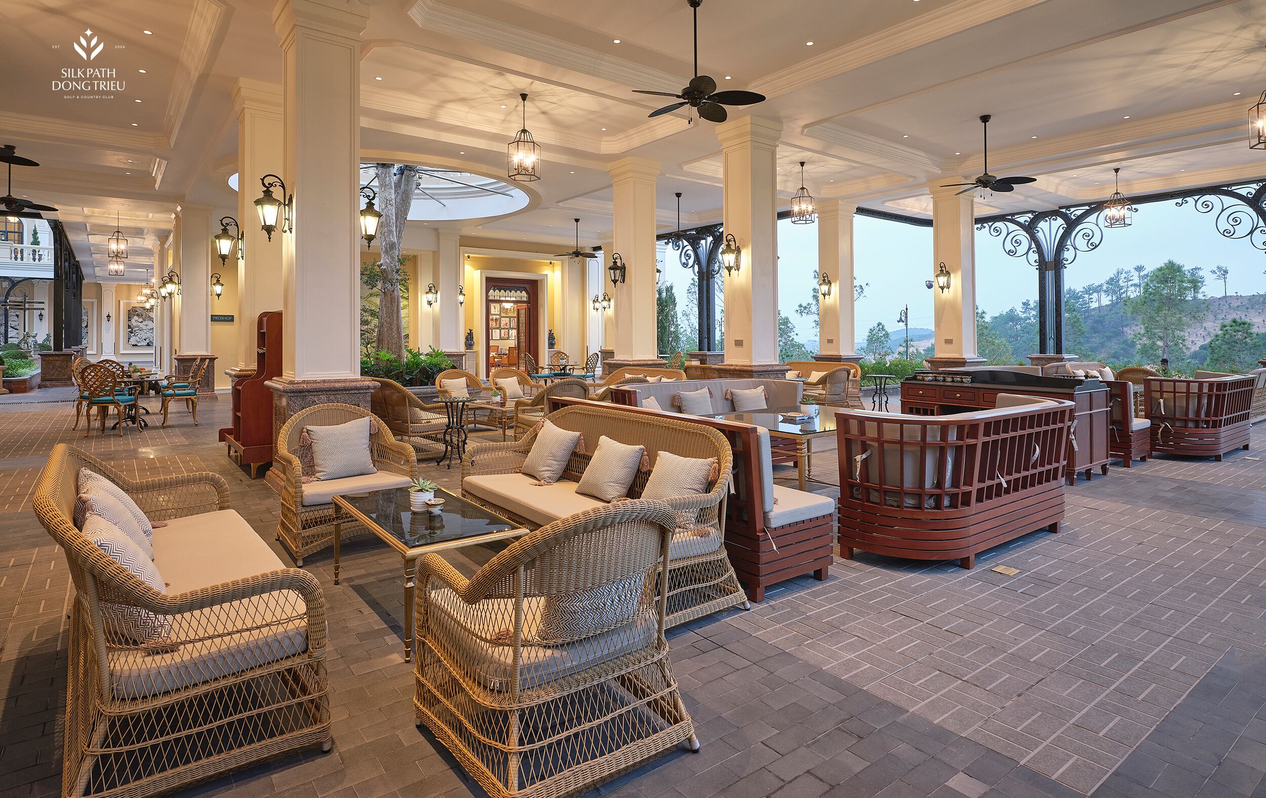 A spacious lobby with wicker furniture, large windows, and a view of the outdoors.