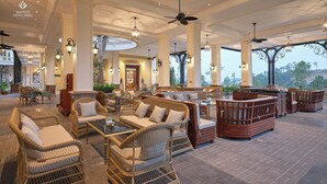A spacious lobby with wicker furniture, large windows, and a view of the outdoors.