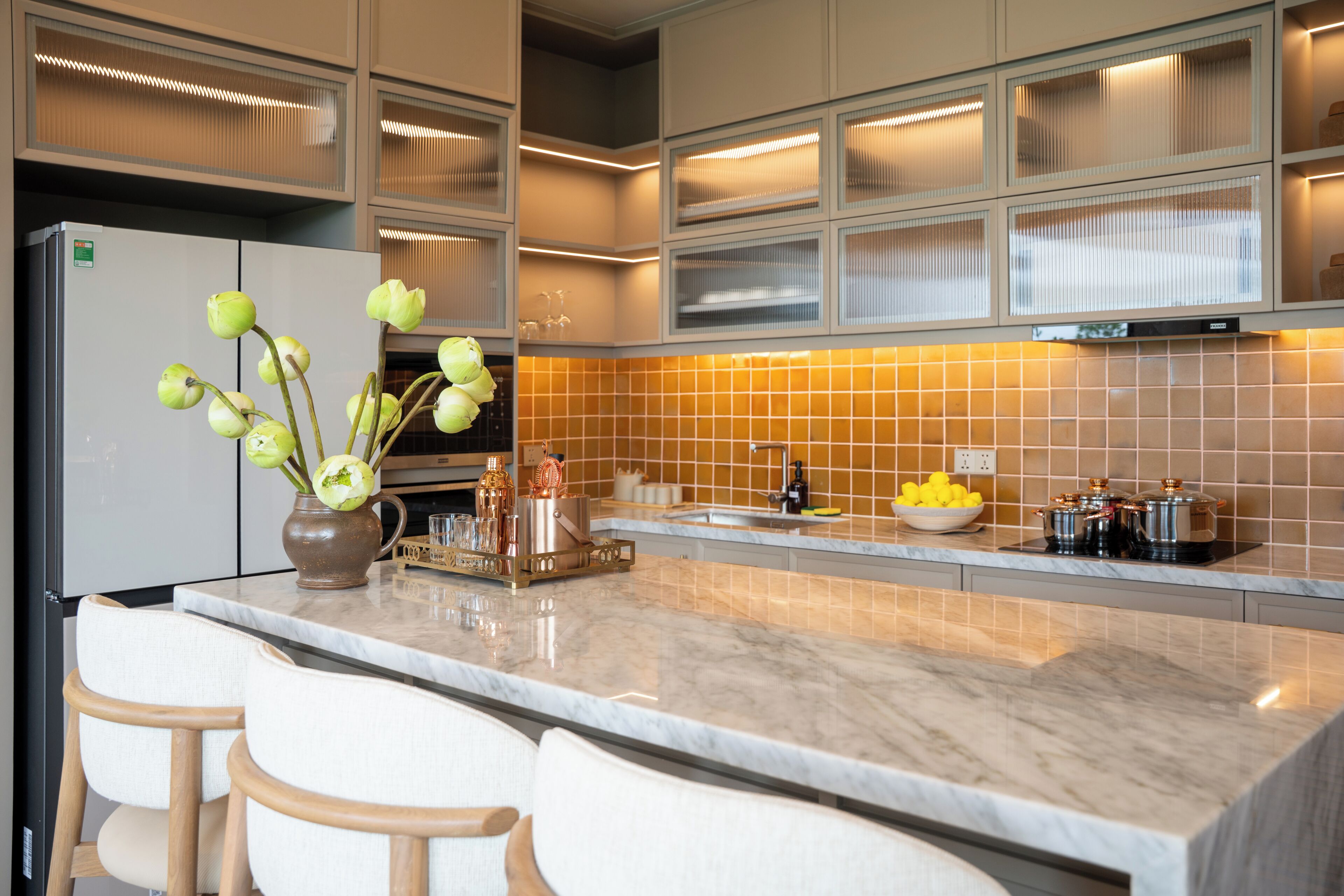 Una cocina moderna con encimera de mármol, horno empotrado y un lavamanos.