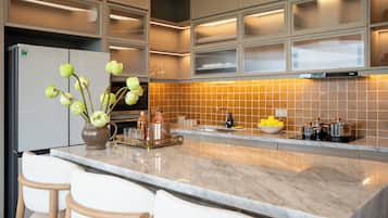 Una cocina moderna con encimera de mármol, horno empotrado y un lavamanos.