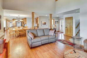 A spacious living area with a sofa, a dining table, and a kitchen in the background.