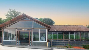 Un edificio con cartel de cafetería, amplias ventanas y tejado de tejas.
