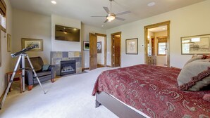 A bedroom with a bed, a fireplace, a telescope, and a ceiling fan. - Stunning Eagle-Vail Escape! Mtn Views + Deck (Avon)