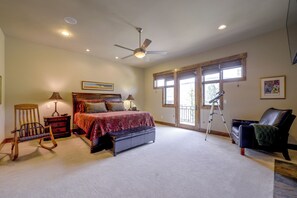 A spacious bedroom with a large bed, a ceiling fan, and a view through the windows. - Stunning Eagle-Vail Escape! Mtn Views + Deck (Avon)