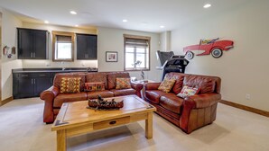 A spacious living room with a brown leather sofa set, a wooden coffee table, and a kitchen in the background. - Stunning Eagle-Vail Escape! Mtn Views + Deck (Avon)