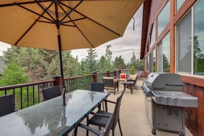 An outdoor patio with a glass table, wicker chairs, a barbecue grill, and a large umbrella. - 7 Min to Slopes! 3BD 2.5BA 5 Beds + Sofa Bed Cabin (Big Bear)